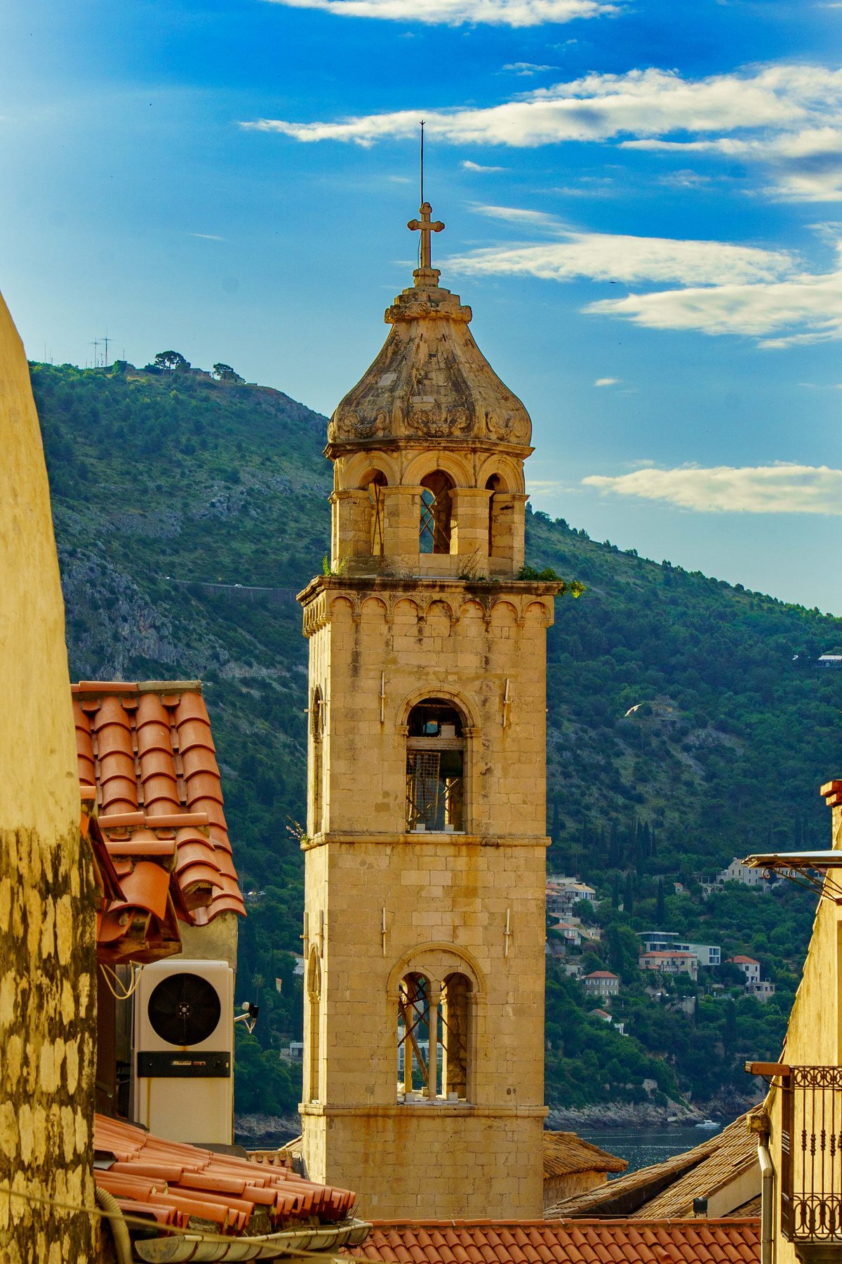 A bell tower rising above Dubrovnik's terracotta rooftops