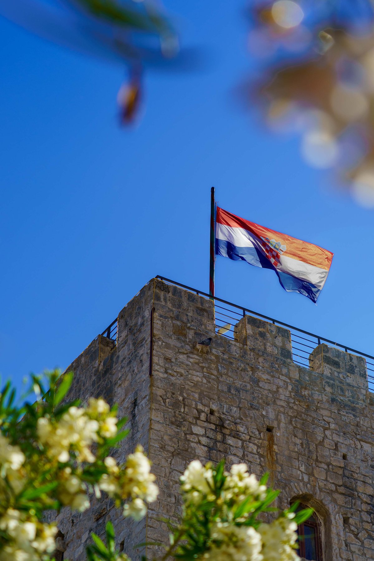 A flag flying over Korčula's old town walls