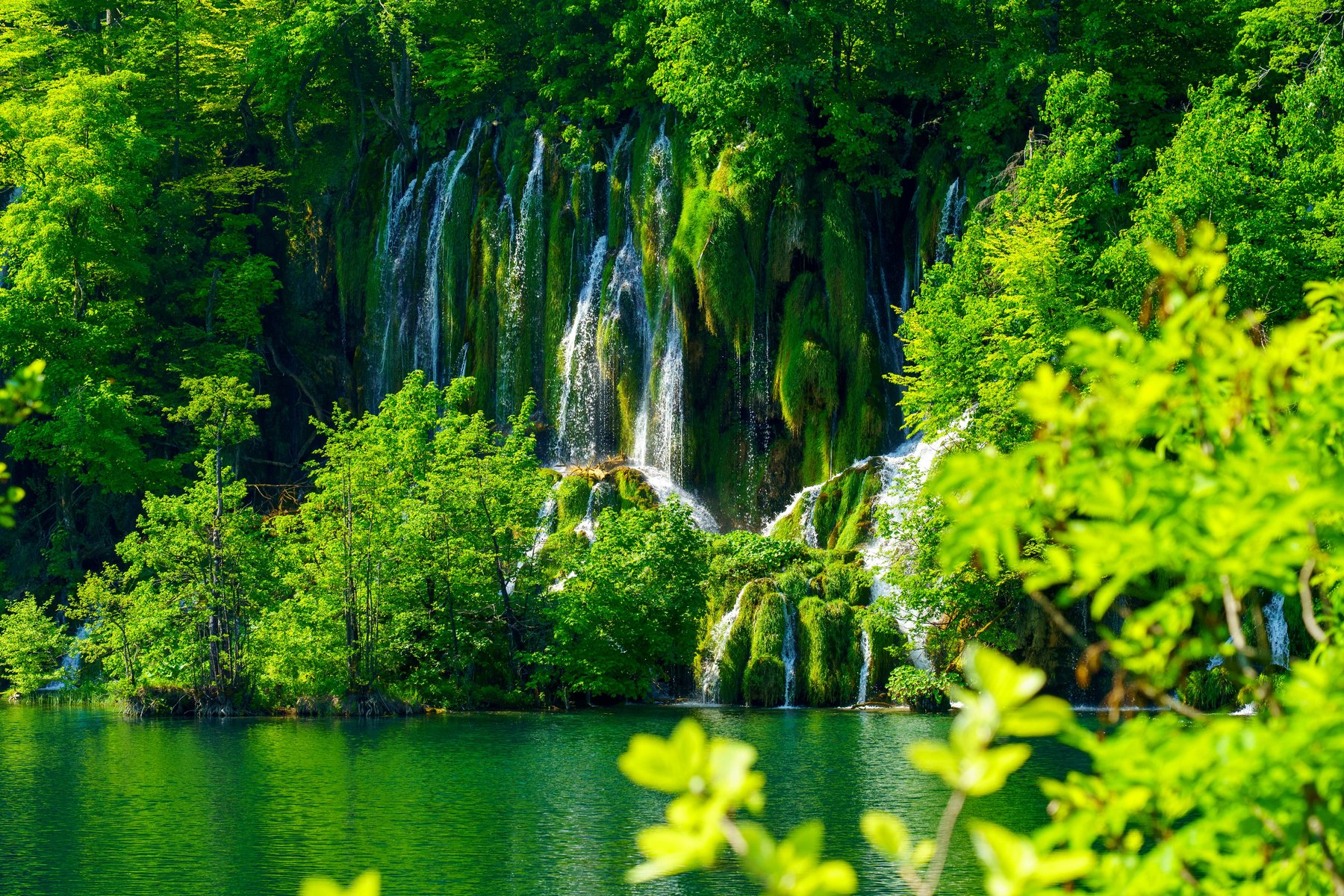 Waterfall cascades spilling into a lake within the canyon
