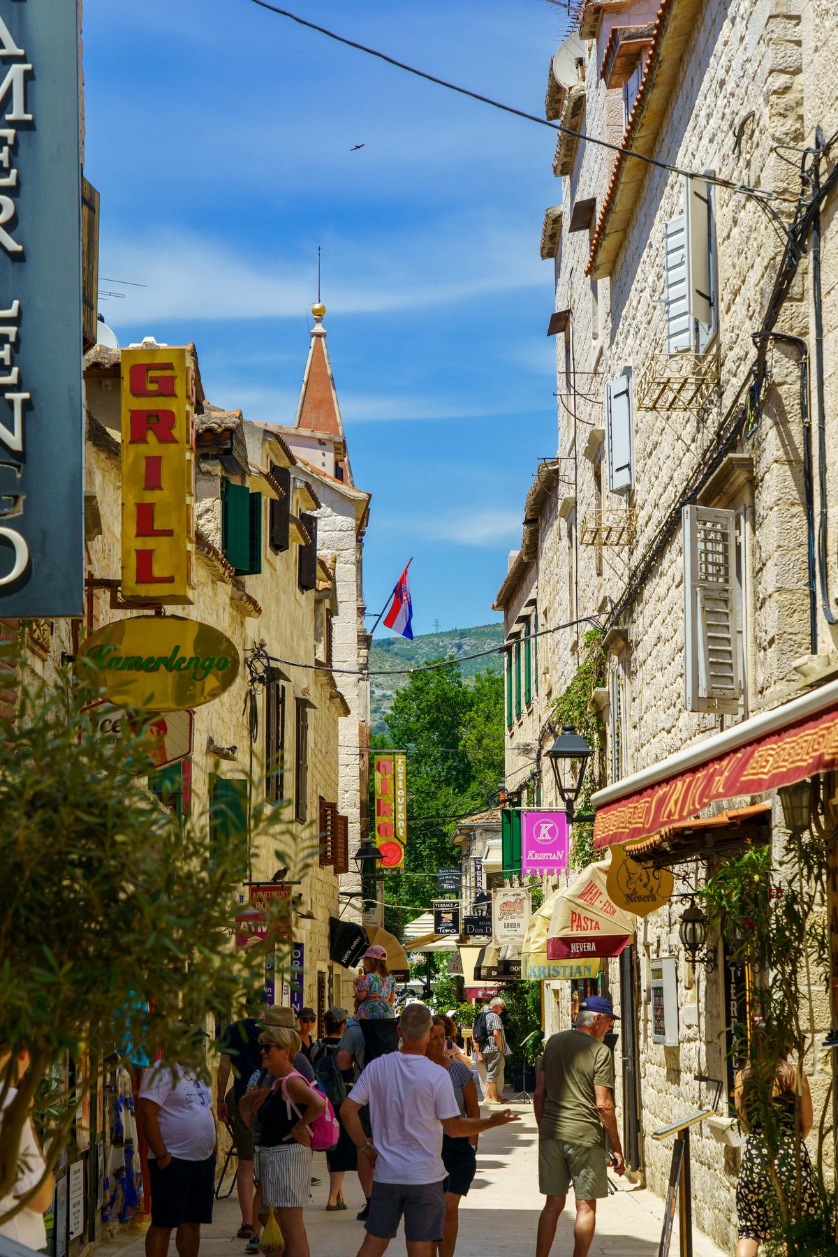 A narrow stone street in Trogir's old town lined with shops