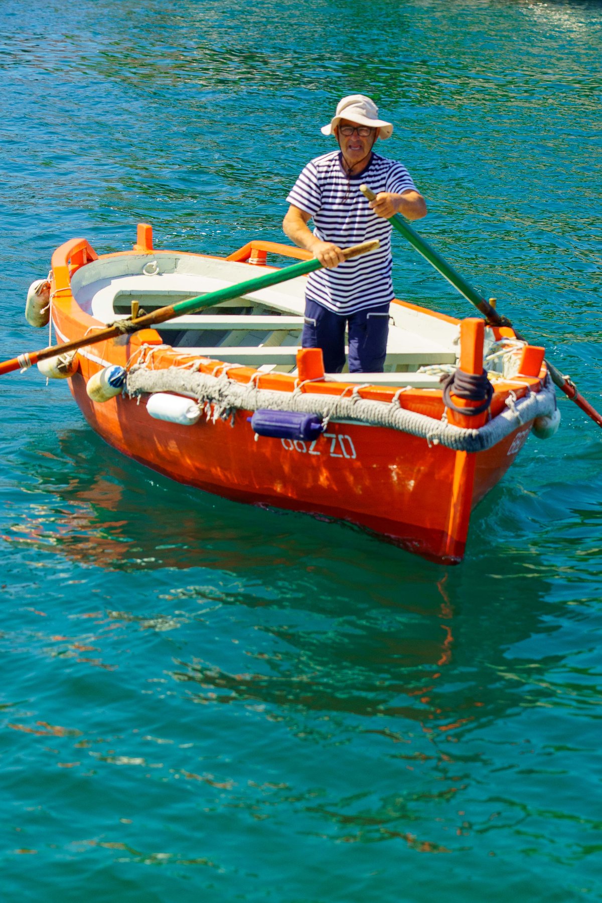 A barkajol rowing a passenger boat across the harbor channel