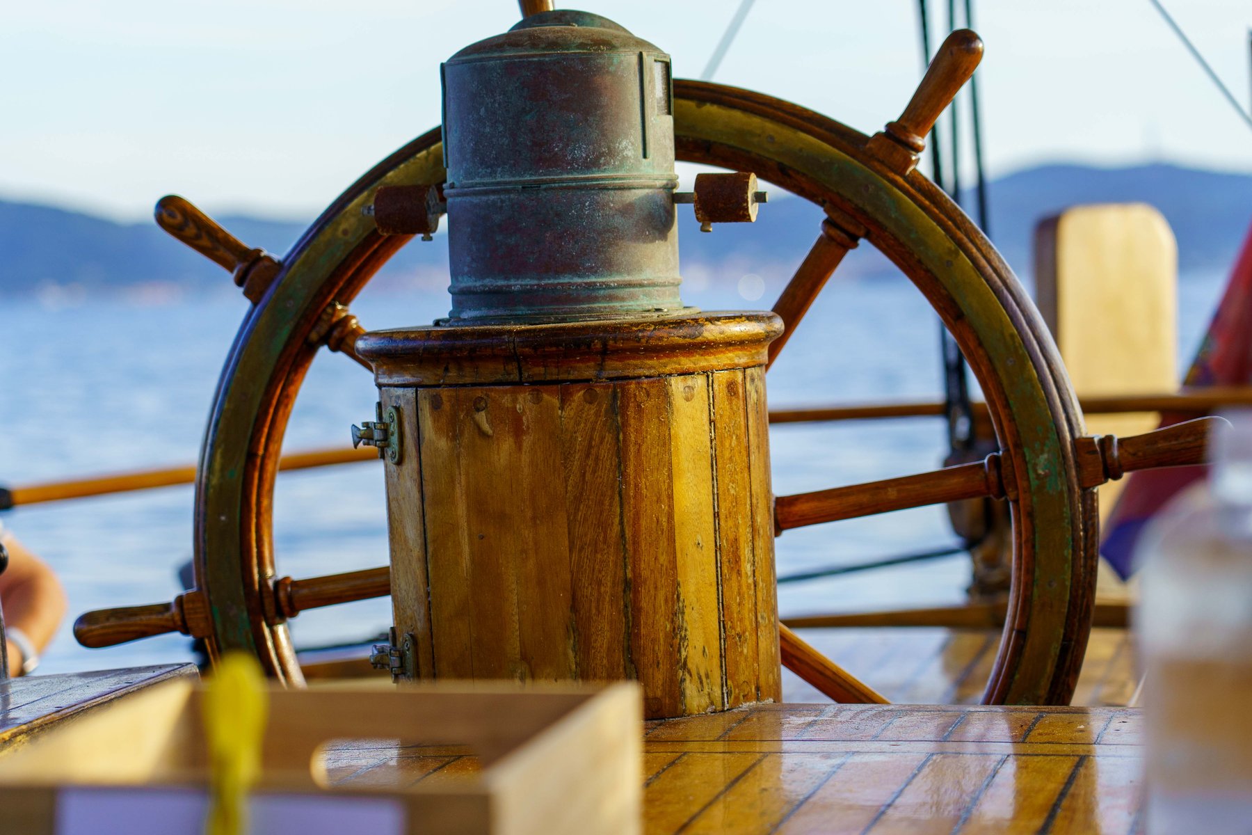 Wooden ship's wheel on a sailboat at golden hour