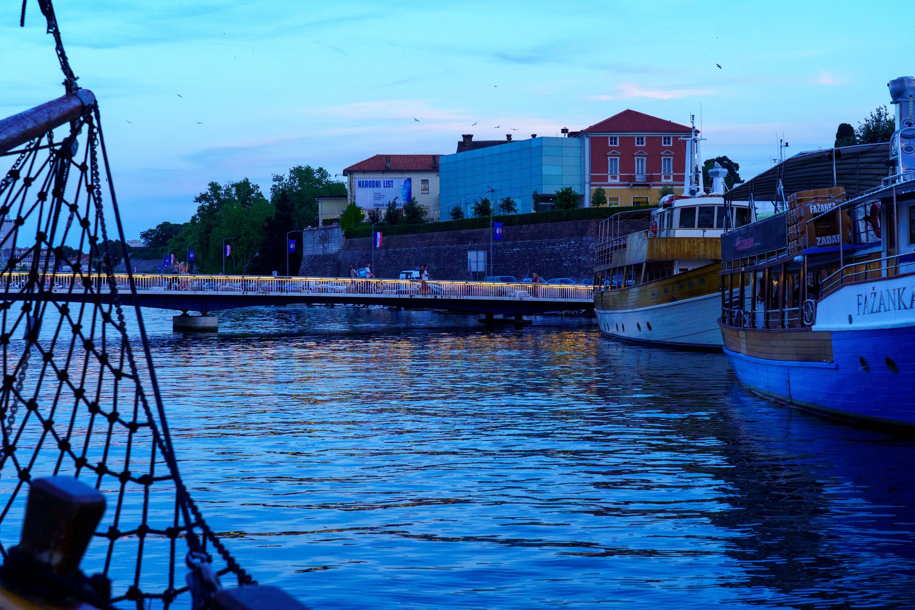 Blue hour over Zadar's harbor bridge and moored boats