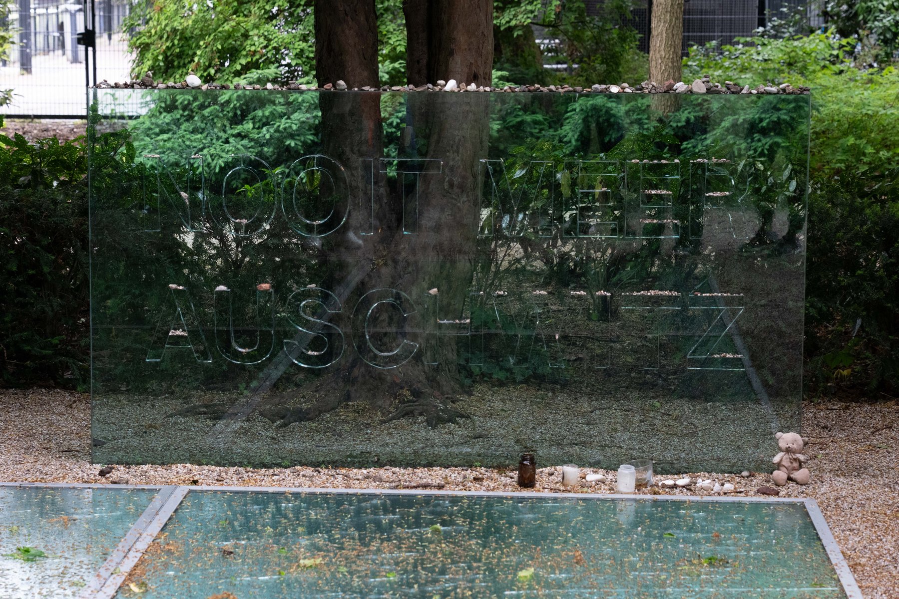 A glass panel reading 'Nooit meer Auschwitz' at the Auschwitz Monument in Wertheimpark