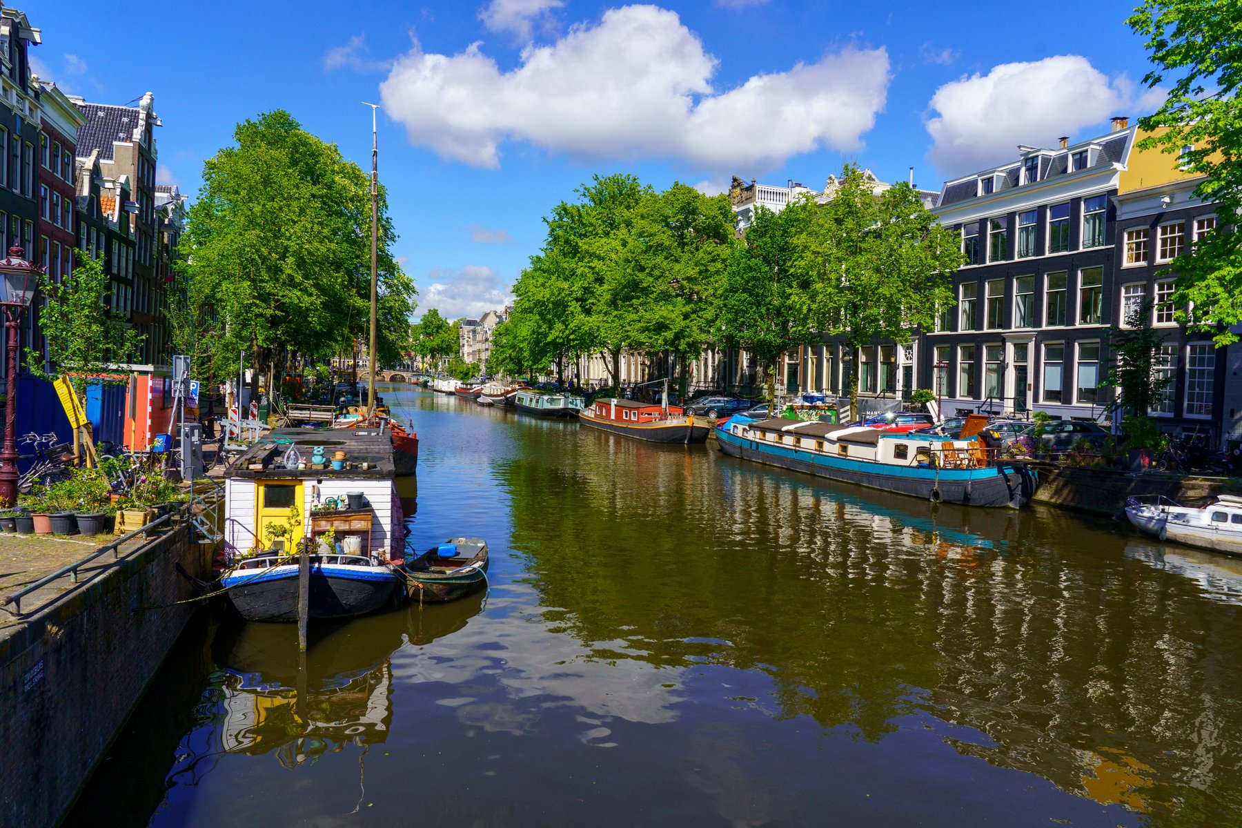 Houseboats lining a sunlit Amsterdam canal