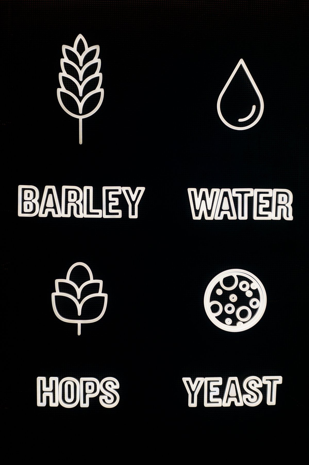 Illuminated signage for the four ingredients of Guinness — barley, water, hops, and yeast — at the Storehouse
