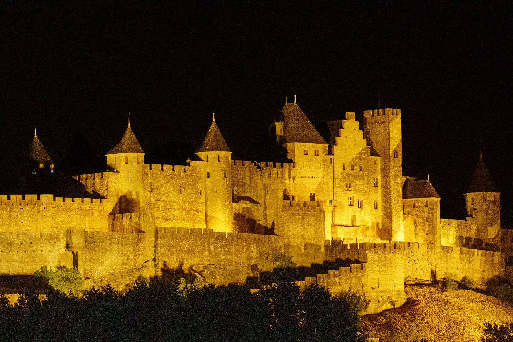 The fortified walls of the Cite de Carcassonne lit up gold at night