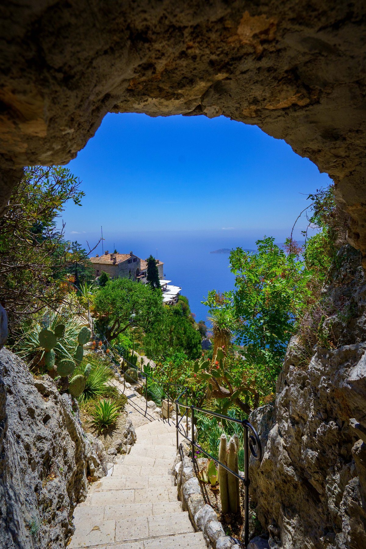 A stone archway framing a stairway down through the Jardin Exotique d'Eze