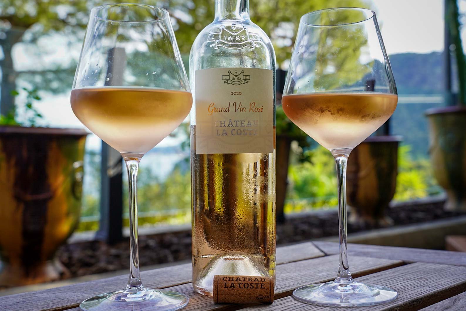 Two glasses and a bottle of Chateau La Coste rose wine