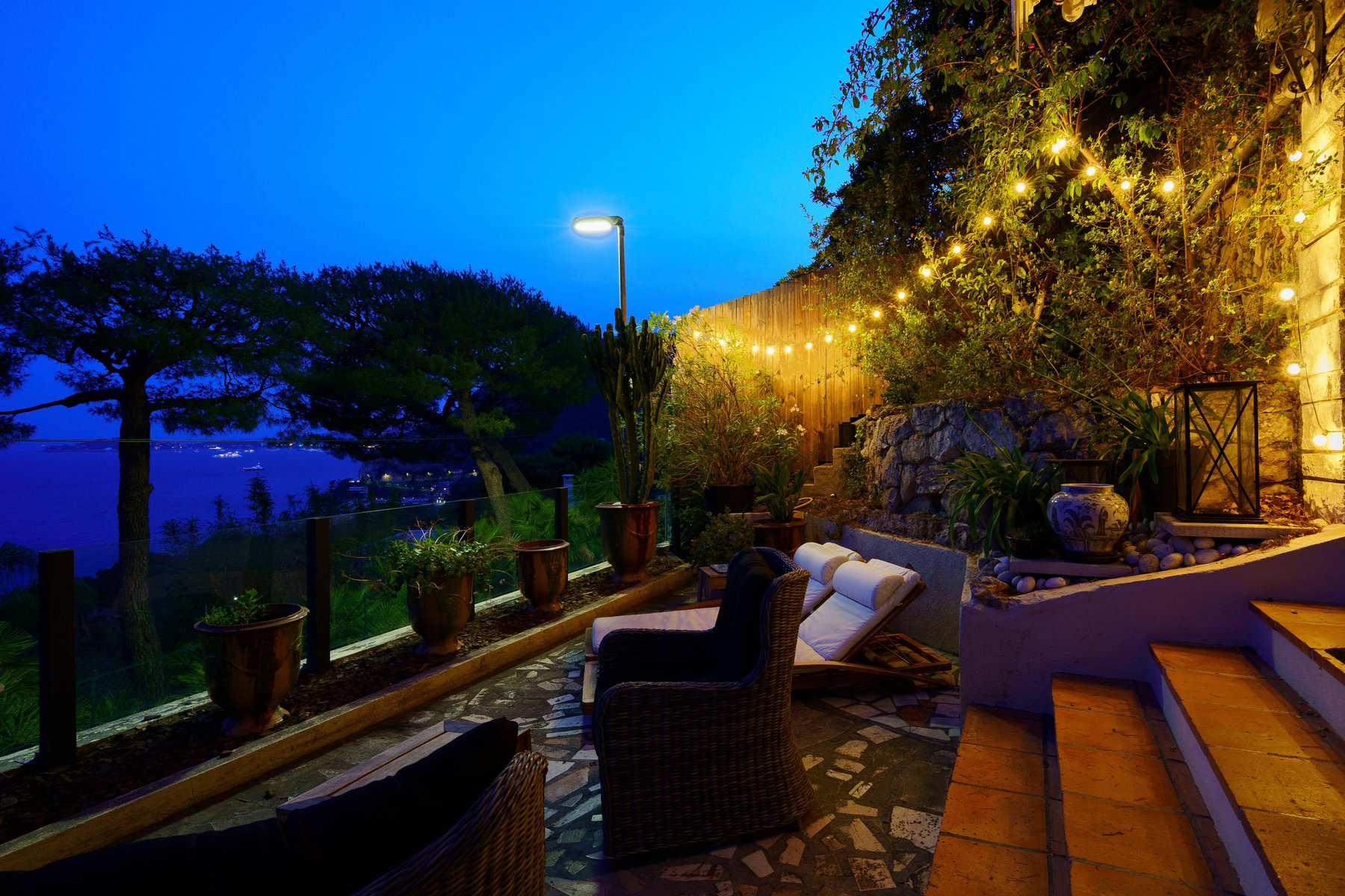 A terrace at night in Eze, the sea just visible beyond the trees