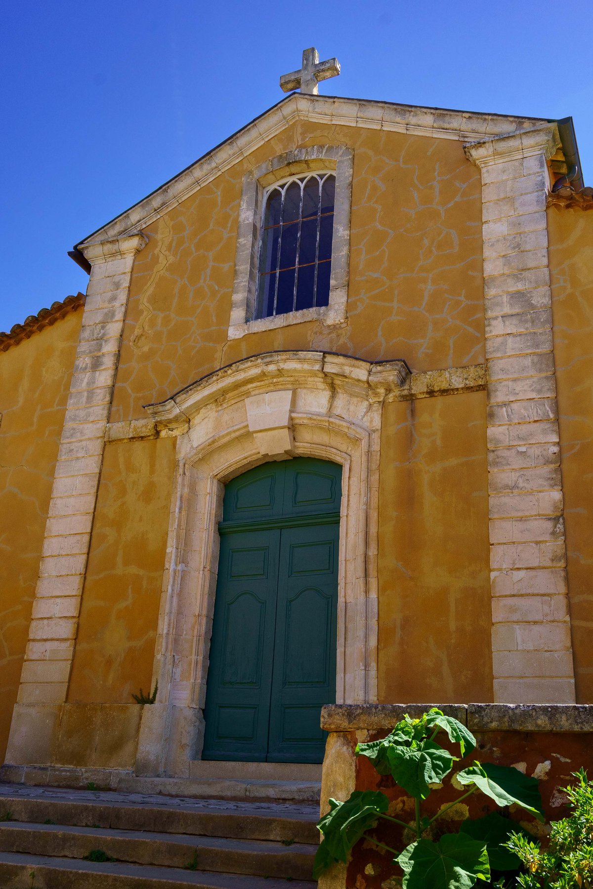 The ochre facade of the Eglise Saint-Michel in Roussillon, France