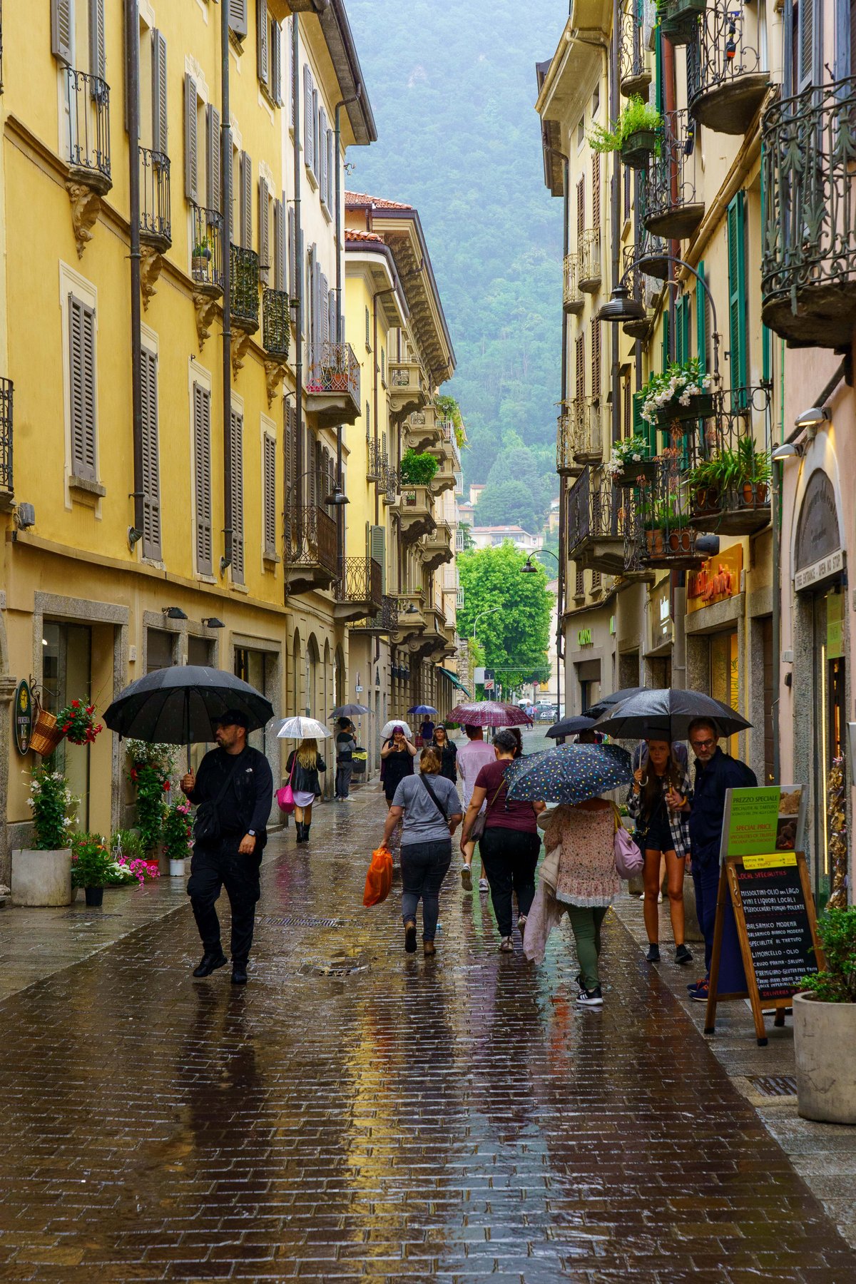 A rainy street in Como with umbrellas out