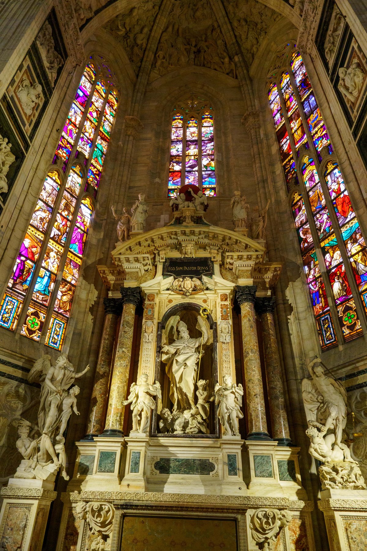 Stained glass windows and marble statuary inside the Duomo di Milano