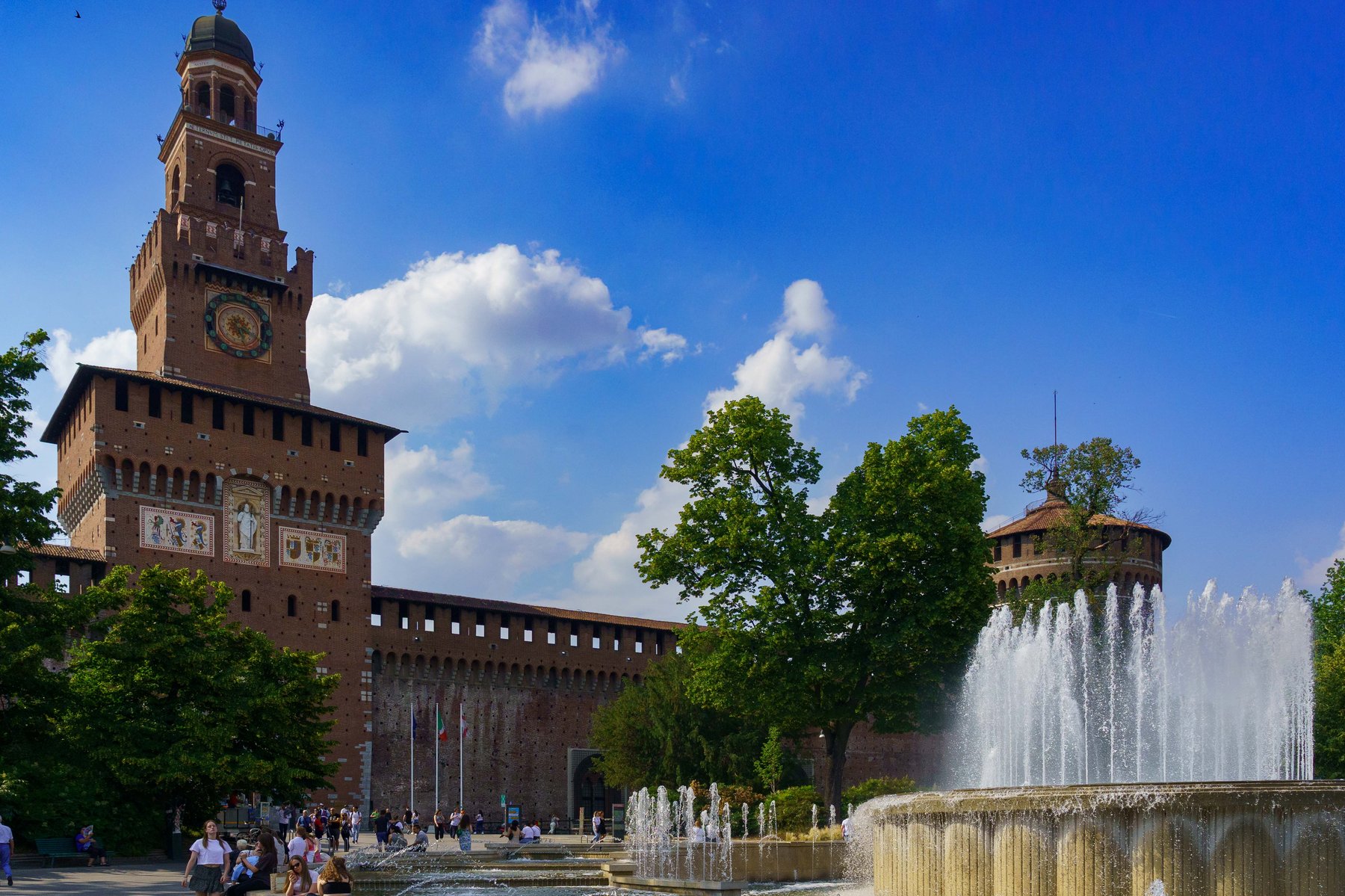 Castello Sforzesco and its clock tower, the Torre del Filarete, above the piazza fountain in Milan