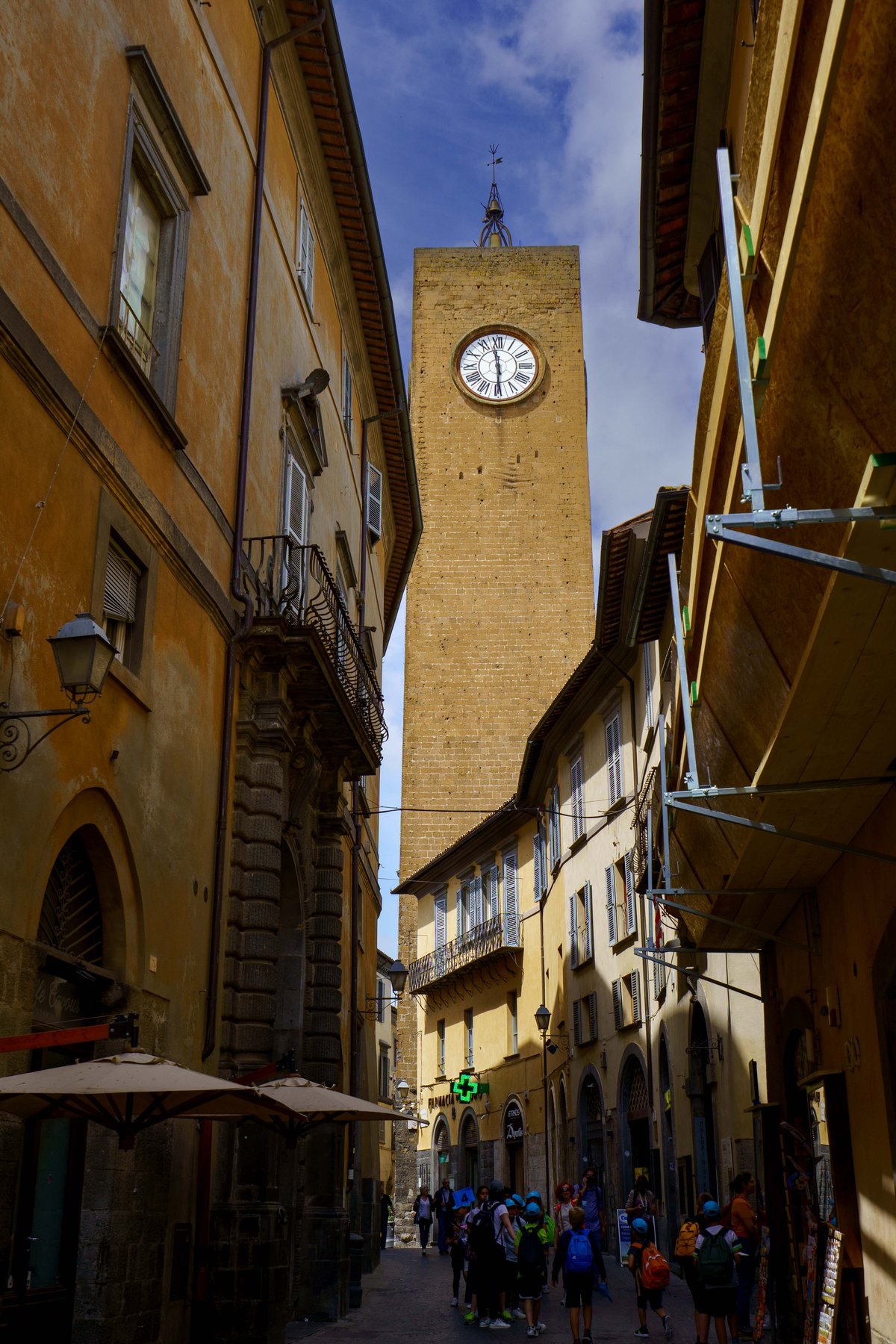The Torre del Moro clock tower rising above a narrow street in Orvieto