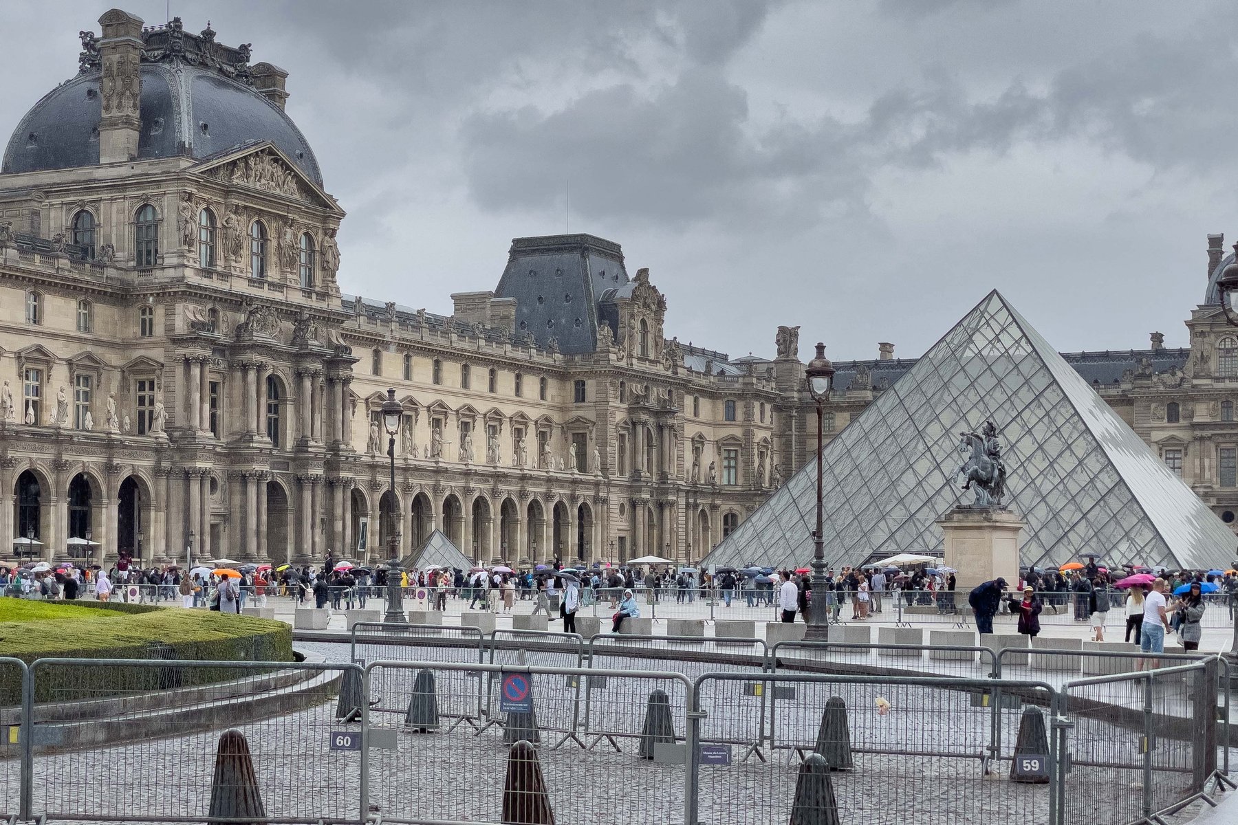 The Louvre and its glass pyramid on a rainy day in Paris