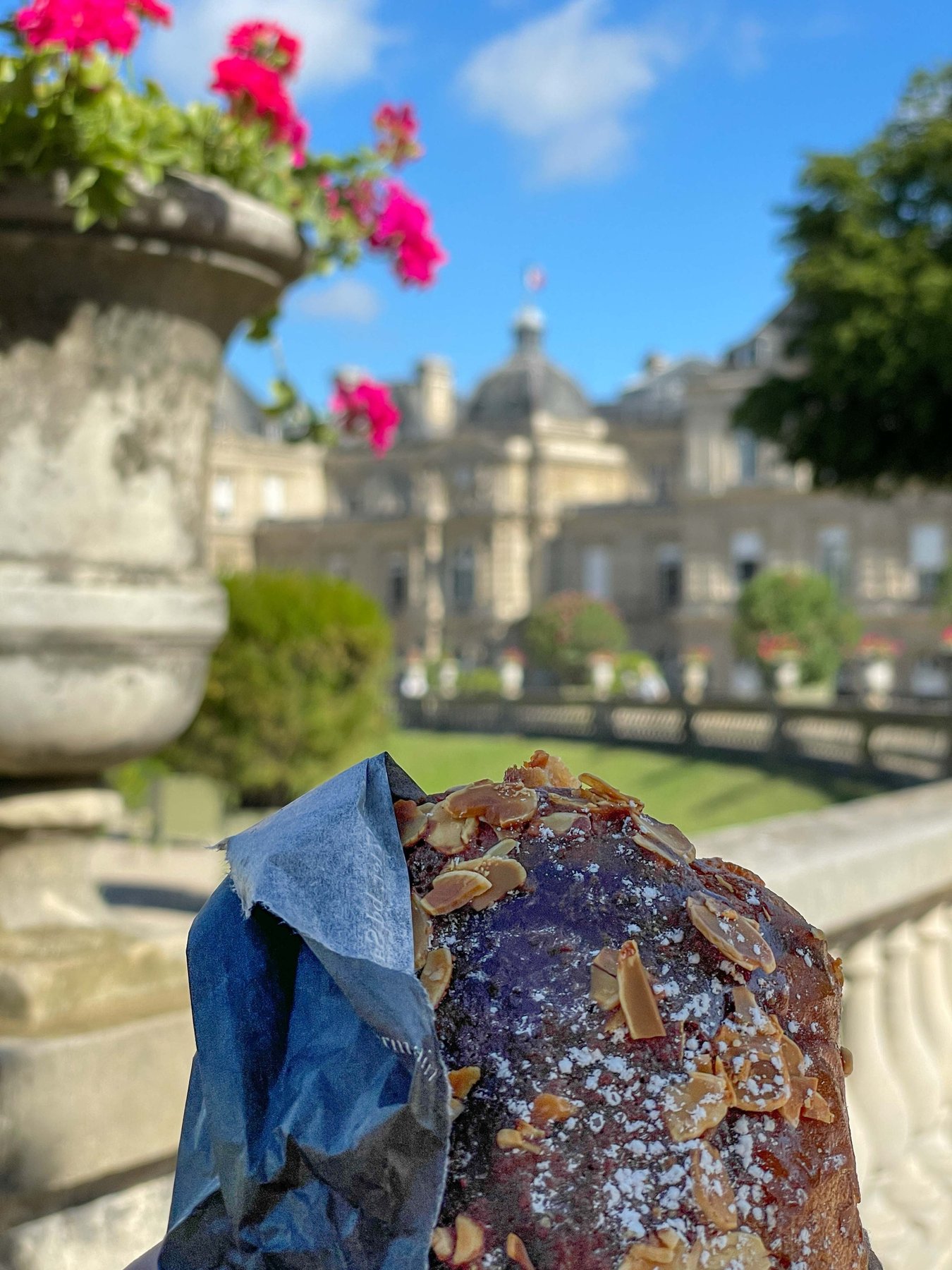 An almond croissant from La Maison d'Isabelle, enjoyed in the Luxembourg Gardens