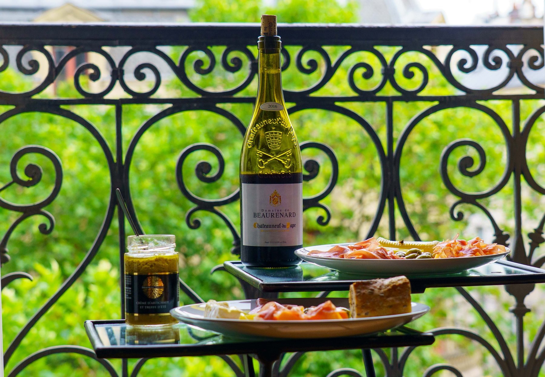 A bottle of Chateauneuf-du-Pape and a charcuterie spread on the balcony in Paris