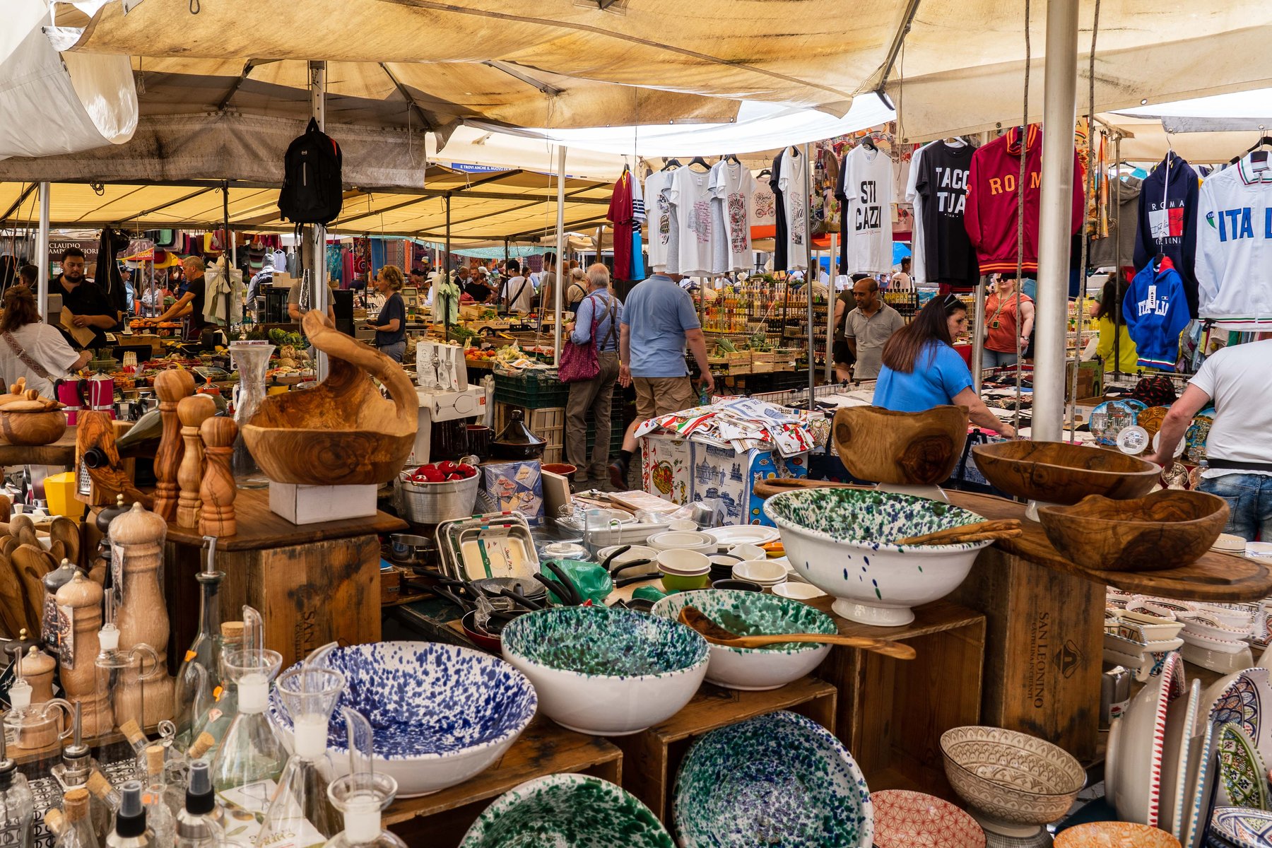Bowls, ceramics, and souvenirs piled high at a Roman street market