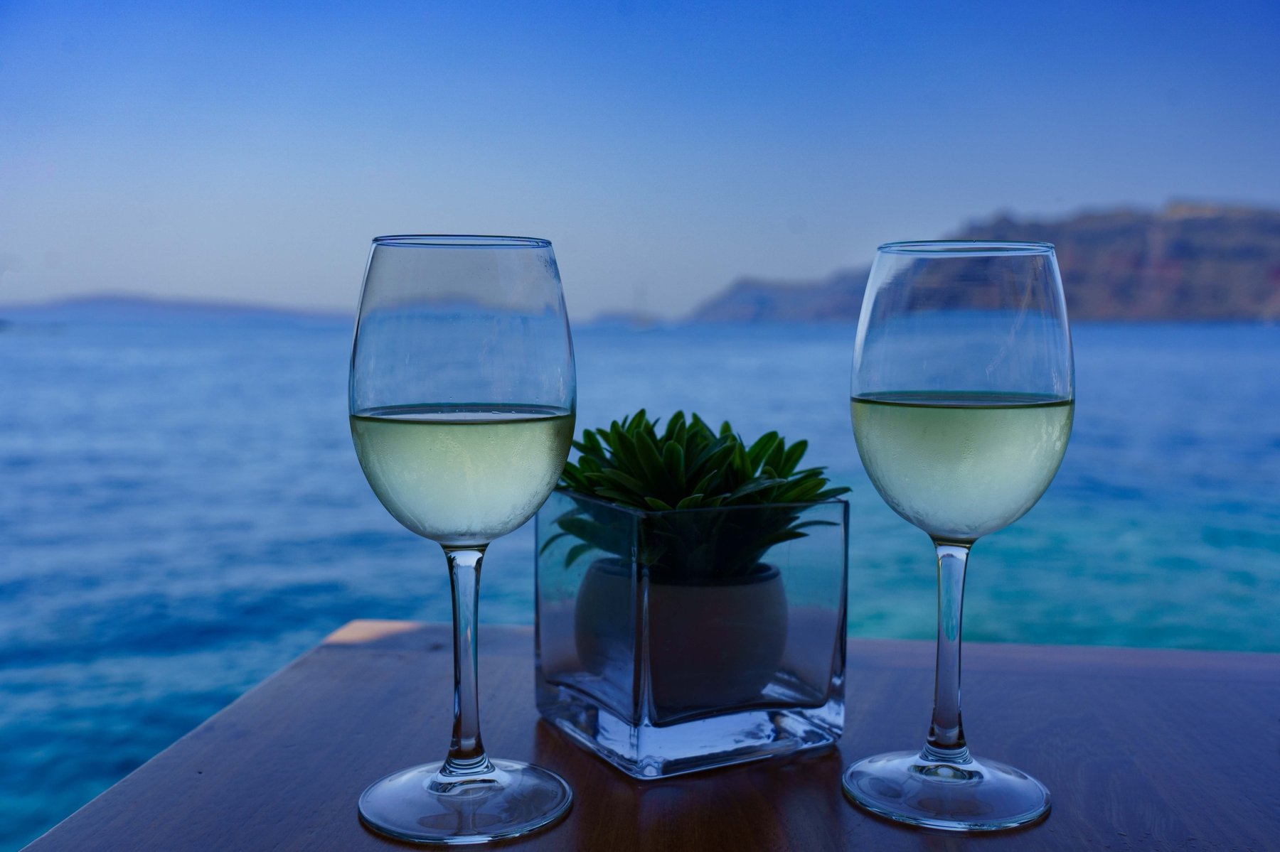 Two glasses of white wine at lunch overlooking Ammoudi Bay in Santorini