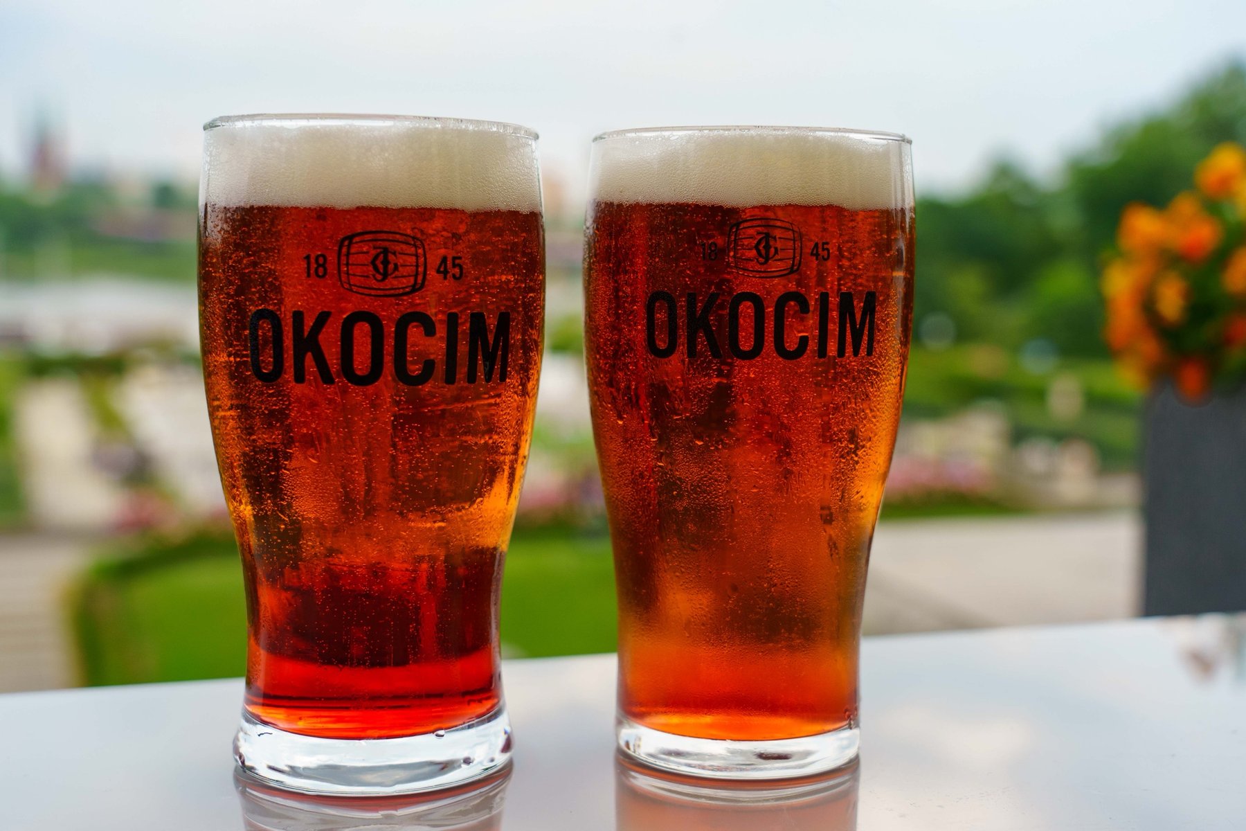 Two glasses of Okocim beer overlooking the gardens in Warsaw