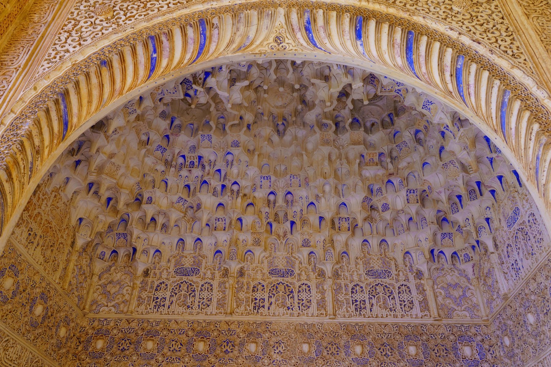 An ornate muqarnas honeycomb ceiling inside the Alhambra