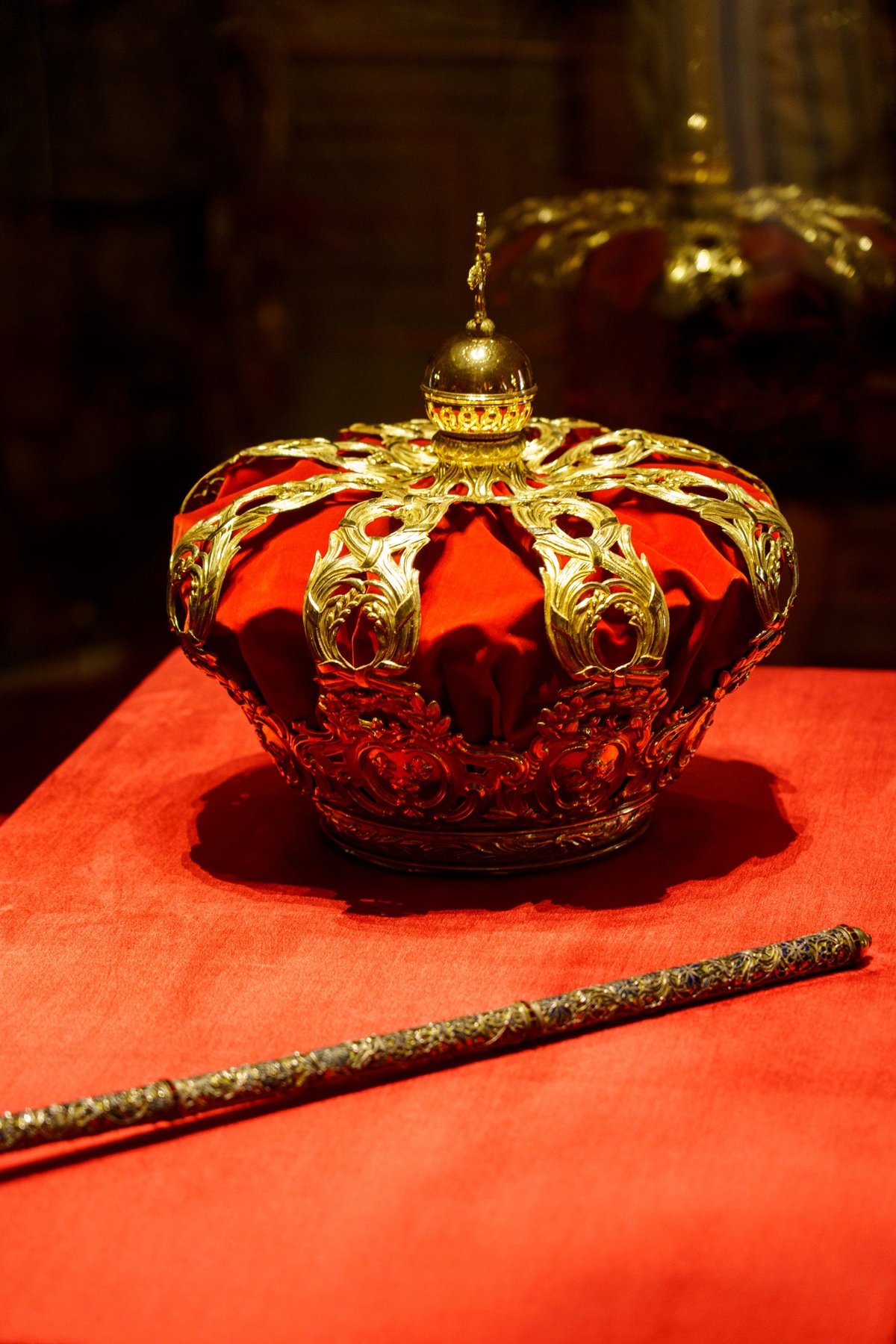 The royal crown and scepter displayed on red velvet in the Royal Palace