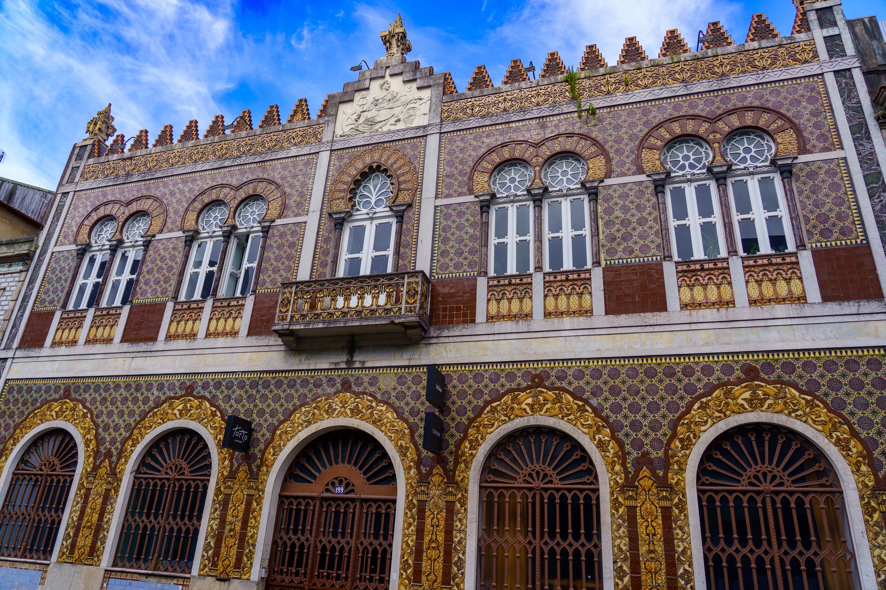 The ornate Moorish Revival tiled facade of an early-1900s building in Porto