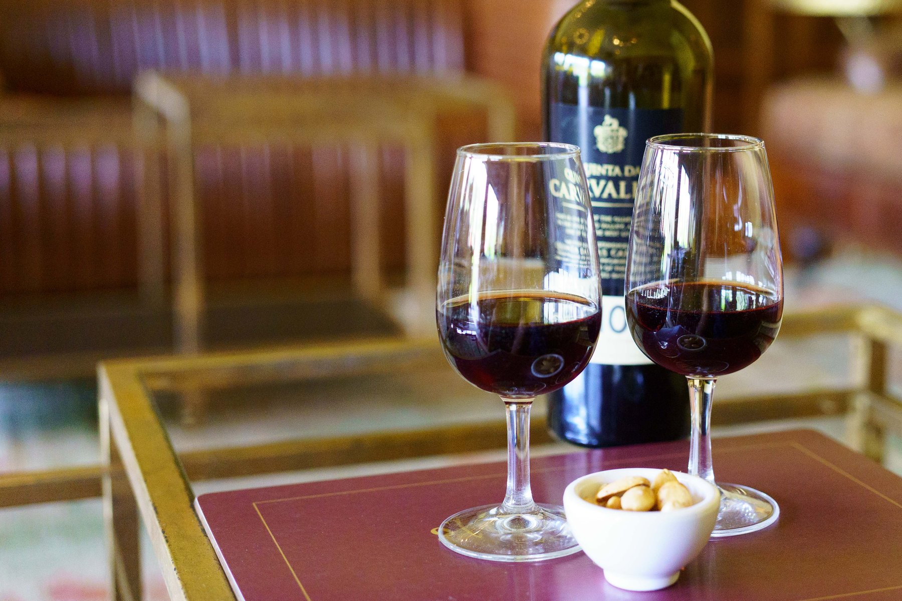 Two glasses of port beside a Quinta das Carvalhas bottle