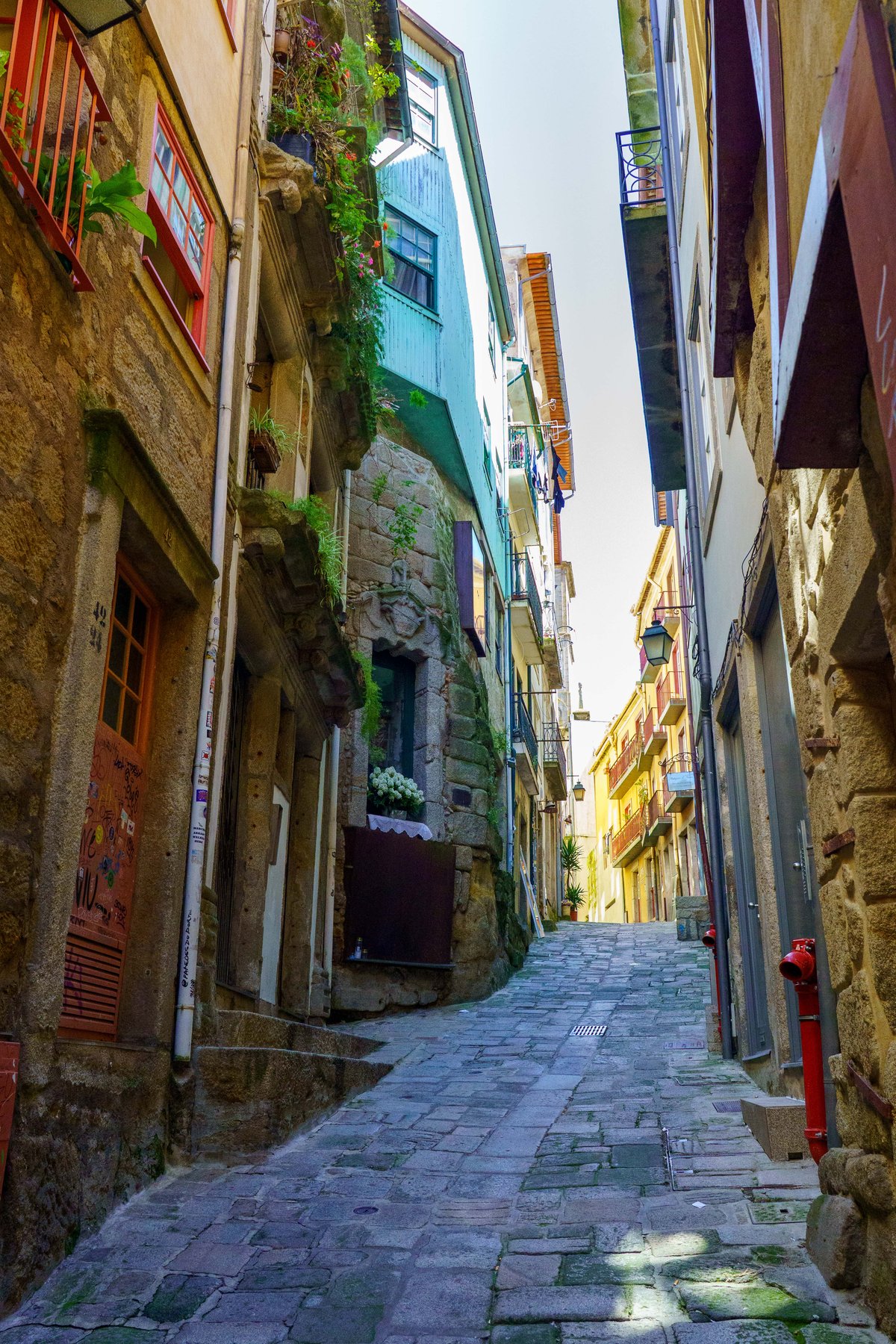 A narrow cobblestone alley between old stone buildings in Porto