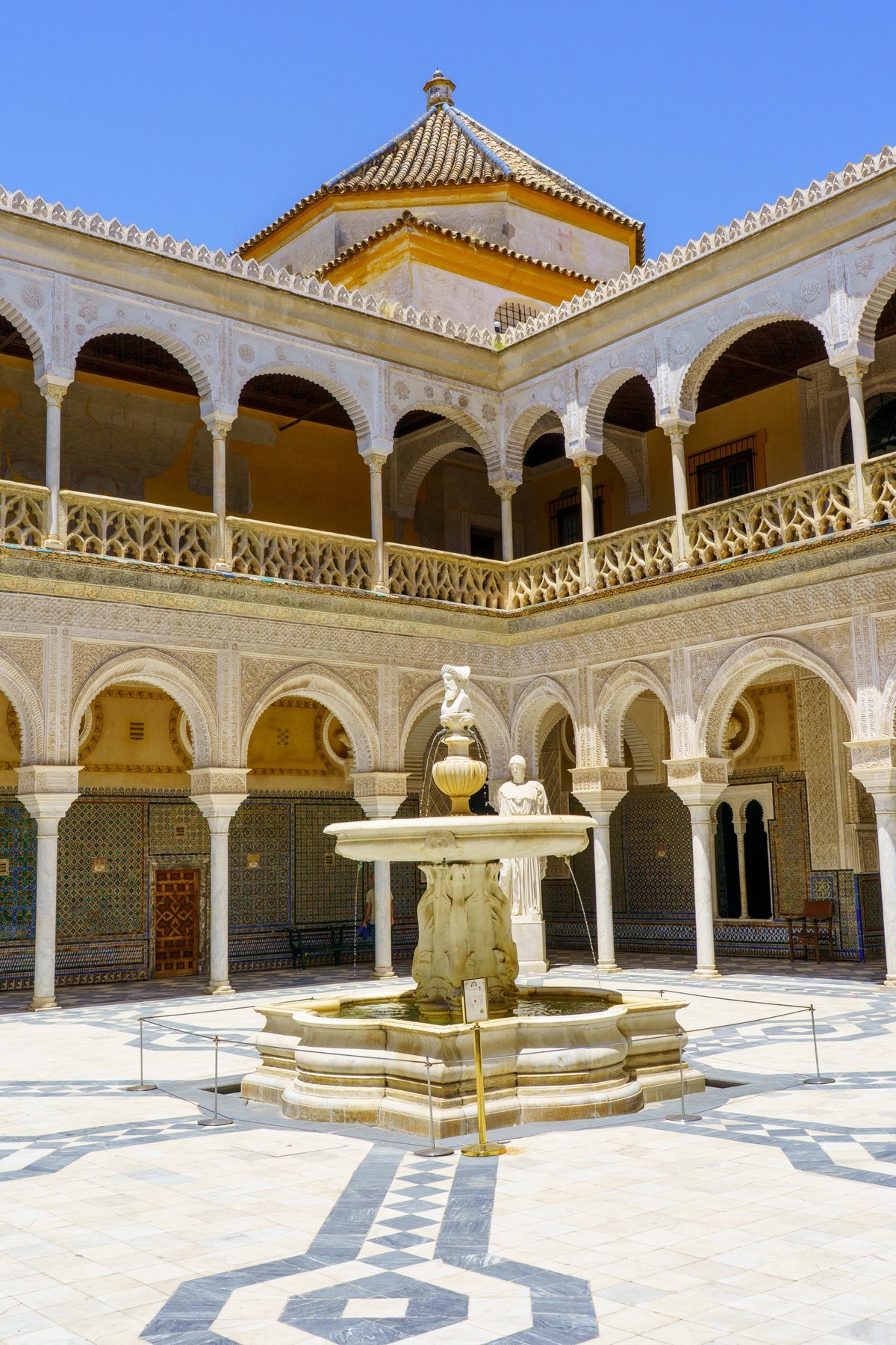 A marble fountain in the arcaded Mudéjar courtyard of Casa de Pilatos