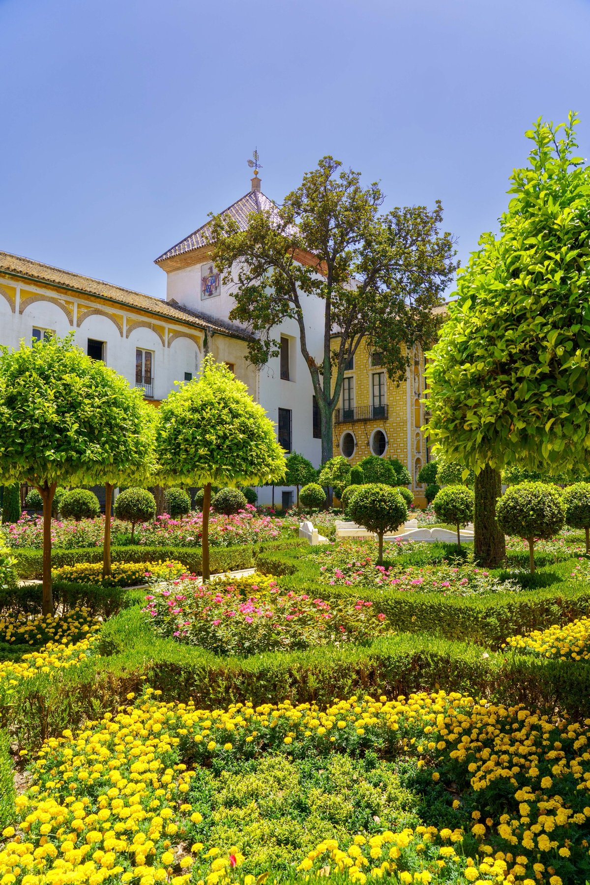 Manicured gardens with topiary and flower beds at Casa de Pilatos