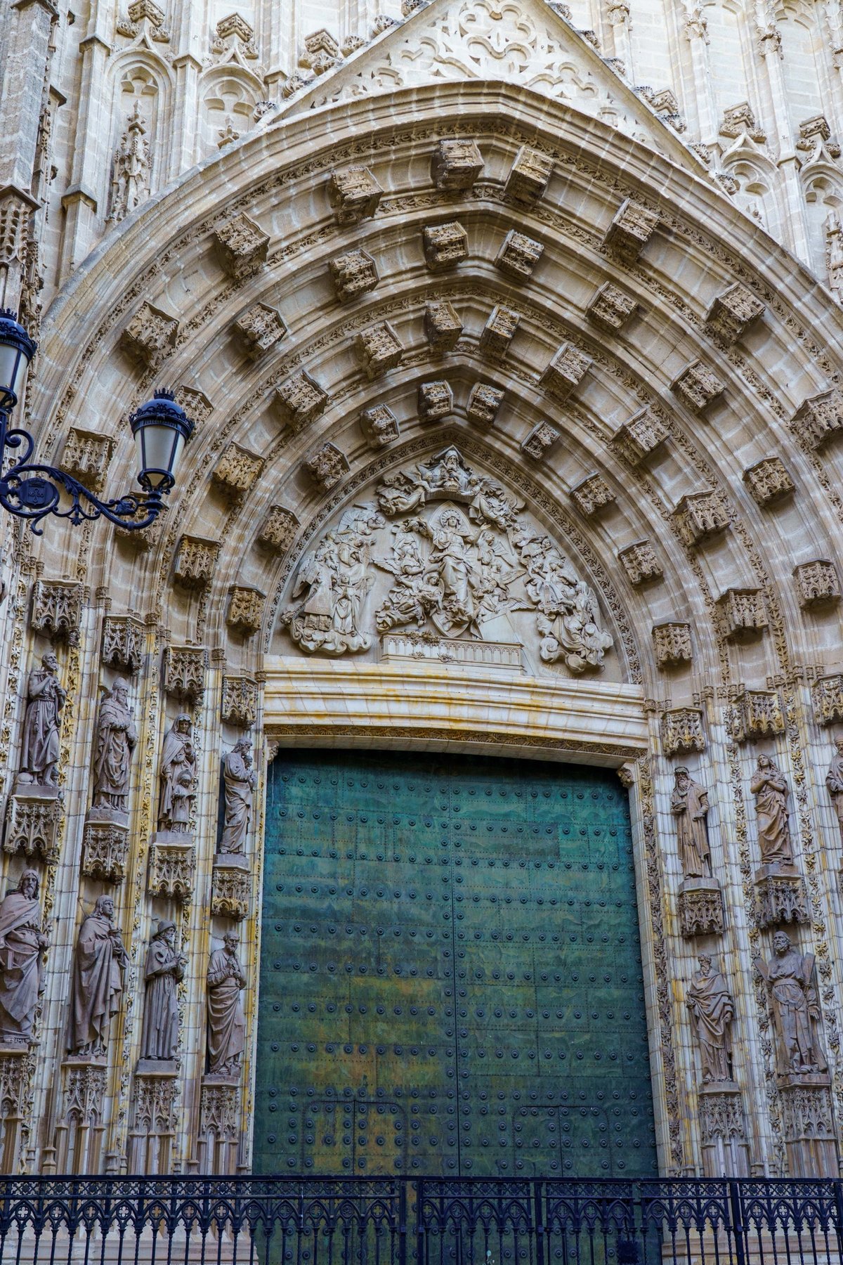 A carved Gothic portal with statues of saints on the Seville Cathedral