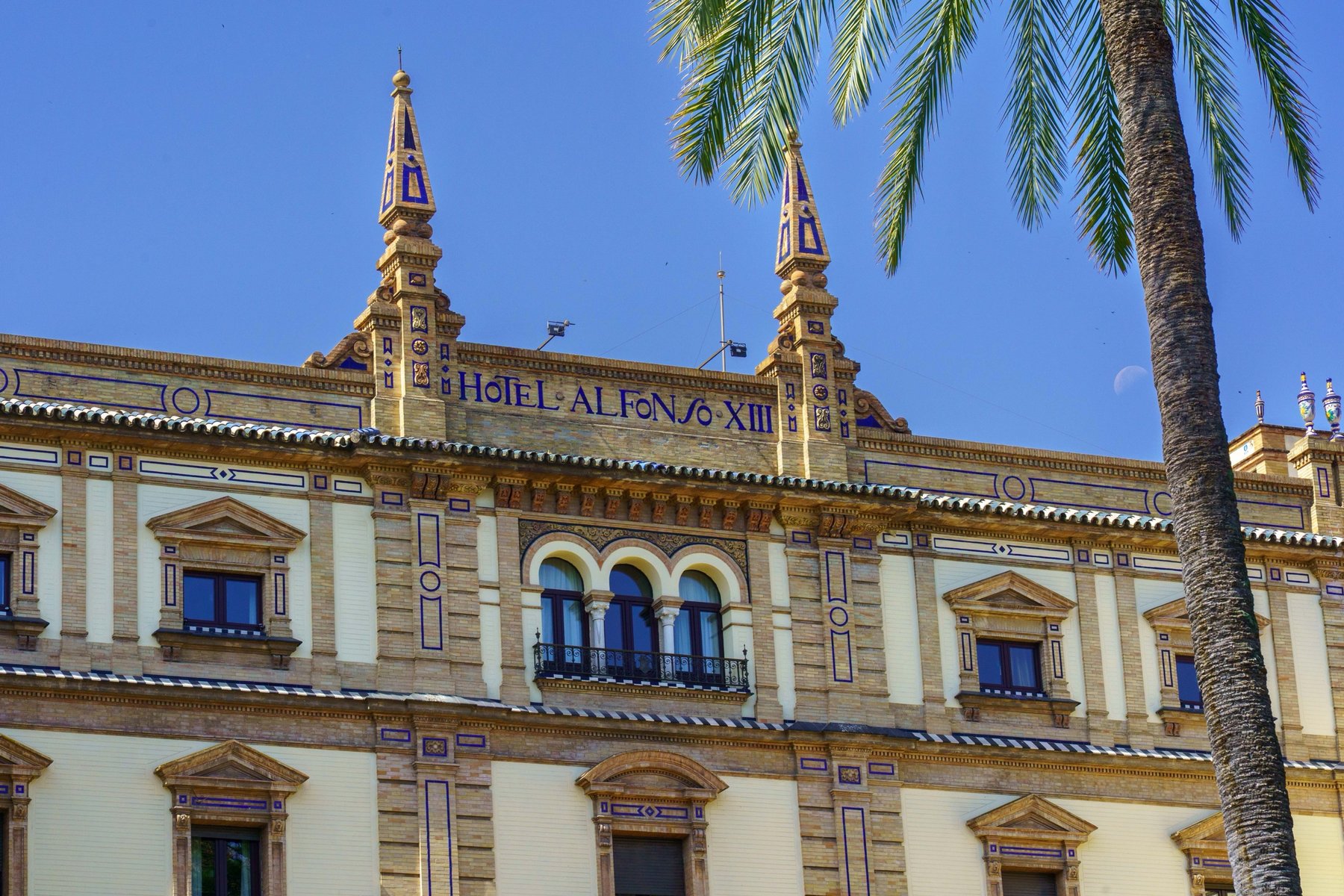 The rooftop and spires of Hotel Alfonso XIII with its name in tile